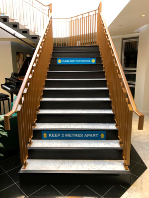 Staircase with "Keep 2 meters apart" stickers
