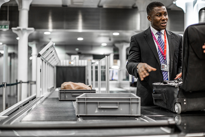 Mitie security personnel performing an suitcase inspection