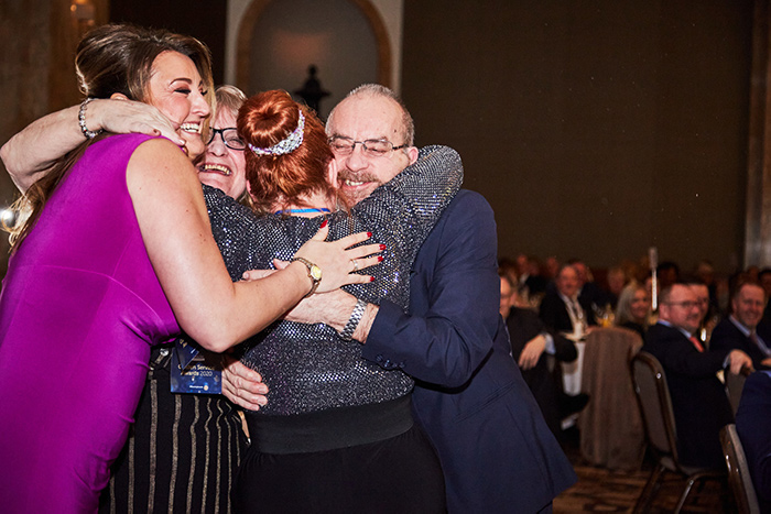Winners of a 2020 Kimberly Clark Professional Golden Service Awards group hug
