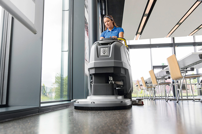 Cleaner using Kärcher scrubber dryer in a meeting room