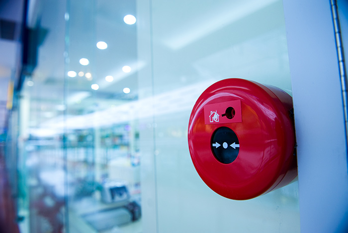 PTSG fire glazing, a fire alarm mounted on a glass wall