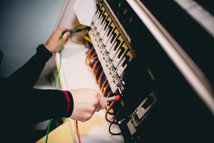 A PTSG electrician working on an electrical switchboard