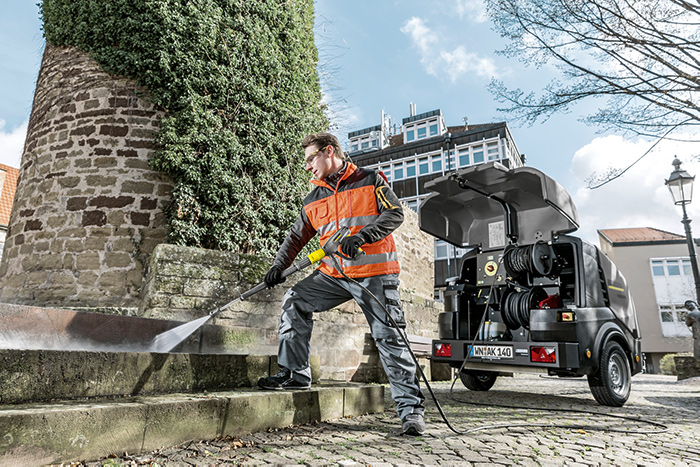 A man cleaning steps with a Kärcher Hire power sprayer