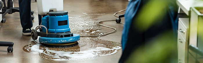 A cleaner buffing the floor in an office
