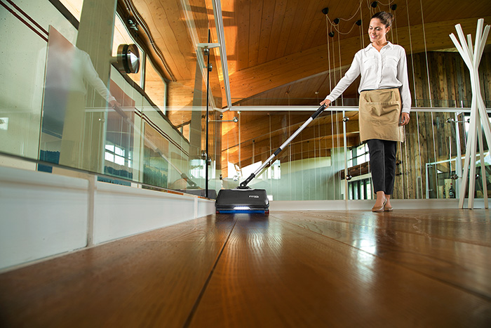 A cleaner polishing a wooden floor