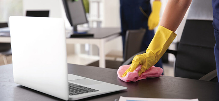 A cleaning working on an office desk