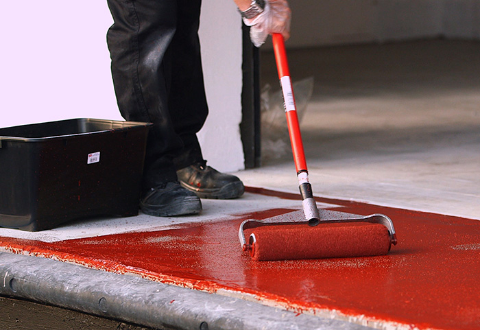 Applying Watco's Safety Grip Red to flooring